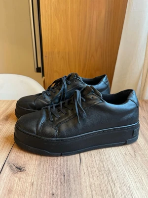 Svarta Vagabond sneakers i skinn - Helsvarta sneakers från Vagabond med chunky plattformsula. Tillverkad i skinn, har snörning och rund tå.  Storlek 40.   Knappt använda men finns små synligheter på användning, se bilder. I övrigt väldigt fint skick!☺️