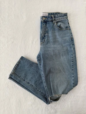 Abrand : S - M : 94 high waist jeans : denim : Ljusblå : 28/ AU 10 - Säljer ett par ljusblå high waist jeans från Abrand Jeans. Klassisk femficksmodell med raka ben och en avslappnad passform. Jeansen har en snygg vintage tvätt och rå kant längst ner på ena benet för en cool touch. Står M men är mer som en S så har därför valt S i annonsen. 