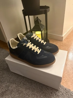 Maison Margiela skor navy blue  - Tja, säljer dessa snygga Maison margiela skor. Dom är i väldigt bra skicka då dom knappt är använda. Säljer dom pga att dom inte passar mig, hör av dig vid minsta lilla fundering, pris ej hugget i sten!