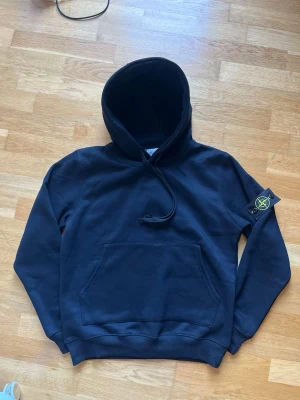 Stone Island hoodie  - Stilren svart hoodie från Stone Island. Skön passform och bra kvalitet. Patch med logga på ärmen som går att ta av.