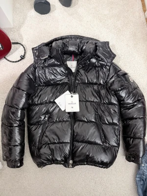 Svart Maya puffer - En svart glänsig maya dun jacka med riktigt dun så den håller dig riktigt varm nu under vintern! Du vet varför priset är som det är. 