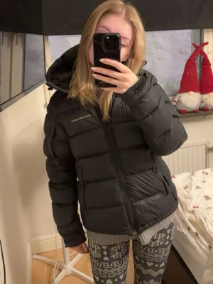 Svart pufferjacka från Peak Performance - Svart Peak Performance dunjacka med huva. Frost down puffer modellen (den tjockare alltså). Går att dra åt längst ner också. Använd men inget alls fel på den. Kostar 4200 ny