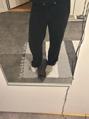 Svarta mjukisbyxor från lager 157 - Säljer ett par svarta mjukisbyxor från 157 med dragsko i midjan och raka ben. Byxorna har två stora fickor framtill och är gjorda i mjukt bomullsmaterial. Perfekta för chill dagar eller när du vill vara bekväm. Storlek 150.