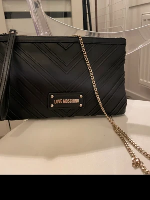 Svart axelväska Love Moschino -  Axelväska från Love Moschino.