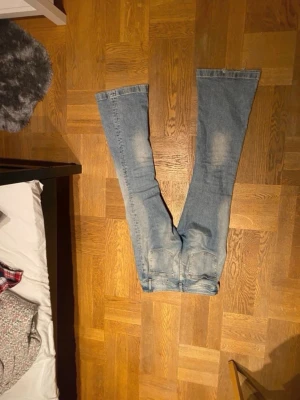 Bootcut jeans i ljusblå denim, stl 28 - Säljer ett par ljusblå bootcut jeans lite slitna nertill.Jeansen har en snygg tvätt och är tillverkade i bomullsdenim. Perfekta för dig som gillar en retro vibe och vill ha ett par jeans med lite extra attityd.