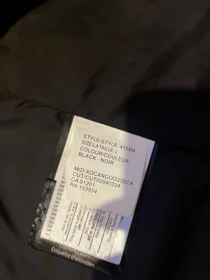 Svart dunjacka från Canada Goose L - Säljer en svart dunjacka från Canada Goose i storlek L. Jackan har klassisk design med hög krage och dragkedja framtill. Perfekt för kalla dagar och riktigt varm tack vare dunfyllningen. Diskret Canada Goose-märke på insidan.