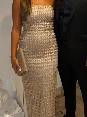 Långklänning med glitter  - Säljer denna snygga klänning som är perfekt till bal eller bröllop. Använd en kväll. Strl 34 men stor i storleken så mer en 36. Stretchig material! Nypris 5800kr mitt pris 3700kr, går att diskuteras vid snabb affär!