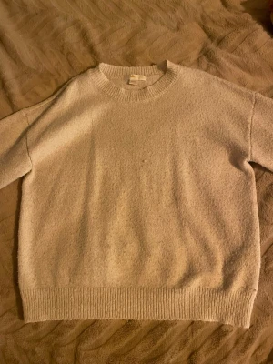 Beige stickad tröja Gina Tricot - Mysig beige stickad tröja från Gina Tricot i storlek 134/140. Tröjan har rund halsringning, ribbade muddar vid ärmslut och nederkant samt lång ärm. Perfekt för lager på lager under kyliga dagar. Dock lite nopprig efter några användningar.