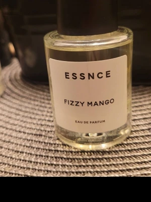 Fizzy Mango Eau de Parfum - ESSNCE Fizzy Mango Eau de Parfum har en modern och stilren look. Perfekt för dig som vill sticka ut med en unik doft i vardagen. Flaskans design är enkel och trendig – ett måste i din samling.