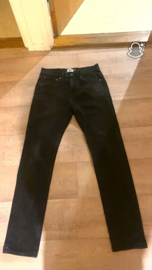 Svarta jeans som passar med allt - Svarta jeans från Lager 157 i storlek W31 L34. Jeansen är inte i toppskick – de har tappat lite färg, men är fortfarande fullt användbara och sitter bra. Inga fläckar, inga hål och inga slitna partier. Bara lite färgsläpp som kommer naturligt med tiden. Snygg, clean passform och funkar till allt.