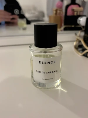 Essnce Eau de Caramel Parfym - Modern Eau de Parfum med stilren design från ESSNCE. Flaskan har tydlig etikett med namnet Eau de Caramel. Perfekt för dig som vill sticka ut med en unik doft. Volym och ingredienser framgår ej på bilderna.