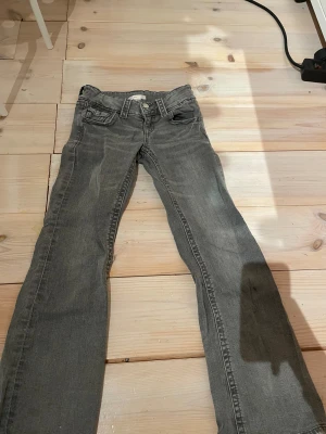 Grå jeans från Gina Tricot, storlek 146 - Snygga grå jeans från Gina Tricot i storlek 146. Klassisk femficksmodell med raka ben och normal passform. Jeansen har bälteshällor, knapp och dragkedja framtill. Perfekta för dig som gillar en enkel och stilren look.