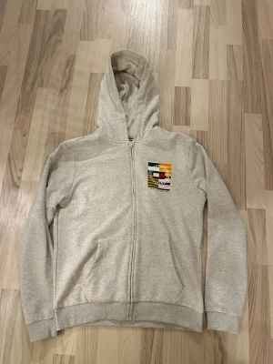 Tommy hilfiger - En zip tröja ifrån Tommy hilfiger med en nice tryck på fram o baksida 