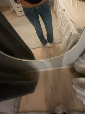 Blå bootcut jeans med låg midja - Snygga blå jeans med bootcut passform och låg midja. Klassisk femficksmodell med kontrastsömmar och dragkedja samt knapp framtill. Jeansen har en cool tvättad look och är tillverkade i mjukt denimtyg som sitter skönt hela dagen. Nästintill aldrig använda!