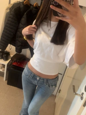 Vit croppad topp med korta ärmar - Säljer en vit croppad topp med rund hals och korta ärmar. Sitter tight runt midjan