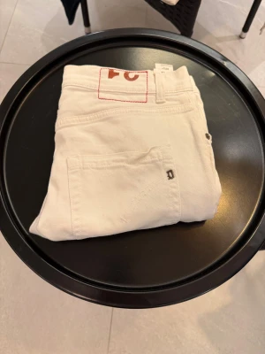 DONDUP jeans - Säljer dessa snygga vita jeans från DONDUP! Jeansen är knappast använda men har en defekt! I jeansen är det ett hål i högra fickan som endast man endast kan se inifrån(sista bilden) men resten av jeansen är i princip nyskick. Modell mius och passform slim fit. Skick 7/10 pris:-599 retail :-2700