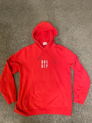 Dondup hoodie - Säljer denna riktigt feta dondup hoodien i röd färg. Den är äkta, men den är i använt skick men finns inga konstigheter med den.  Höjden på hoodien är 68cm och midjan är 52cm. Om du vill ha flera bilder är det bara att höra av sig.