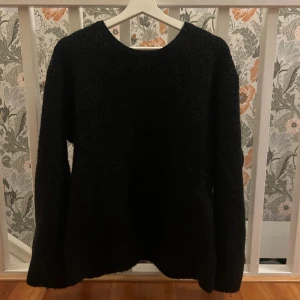 Svart stickad tröja från Gina - En enkel stickad tröja med en fin detalj i ryggen, passar bra till flera olika tillfällen. Endas använd 1 gång så den är ny, tröjan är i storlek M. 🩷