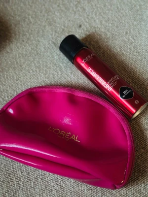 GIFT SET- L'Oréal Infallible Setting Mist - Barely used - L'Oréal Infallible 36H Setting Mist i röd metallisk flaska med svart lock. Medföljer en snygg, glansig sminkväska i ceriserosa med guldfärgad L'Oréal-logga. Perfekt för att fixera sminket och ha allt samlat i väskan.