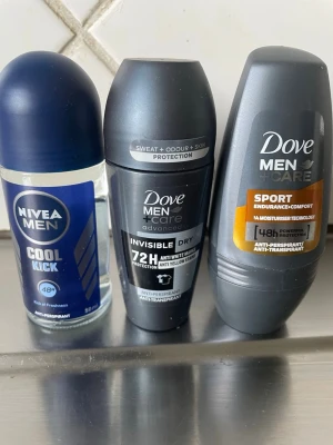 3-pack herrdeodorant Nivea & Dove - Säljer tre herrdeodoranter: Nivea Men Cool Kick i blått glas, Dove Men+Care Invisible Dry i svart plast och Dove Men+Care Sport Endurance+Comfort i grå plast. Alla är roll-on och anti-perspirant, perfekta för fräsch känsla hela dagen.
