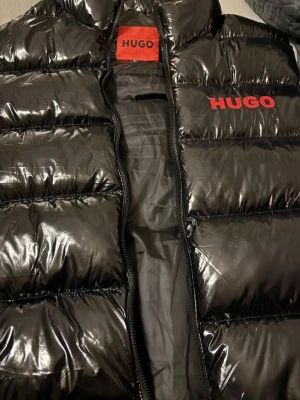 HUGO VÄST  - .🧥✨ SNYGG HUGO VÄST TILL SALU! ✨🧥 Superfin, glansig svart HUGO väst – nästan som ny! 😍 Perfekt för både vardag och stiliga outfits.