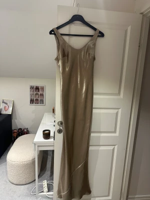 Champagnefärgad balklänning i satin - Champange färgad balklänning med djup urringning i ryggen. Storlek S/M, sitter så fint, har små defekter, men annars bra skick💛✨BUDA PÅ!!