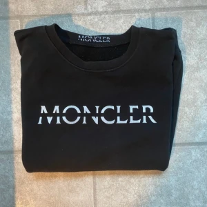 Svart moncler tröja  -  En svart moncler tröja,Parfekt nu för vintern, inga defekter riktigt fint skick, köpt för några år sedan men knappt använt å hittade den nu när jag gick igenom garderoben å hade glömt bort den helt den är mellan S-M 
