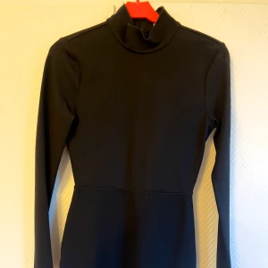 Svart långärmad klänning Lovers + Friends - Aldrig använd svart klänning från Lovers + Friends i storlek S. Modellen har lång ärm, halvhög krage och en figurnära passform. Dragkedja i ryggen