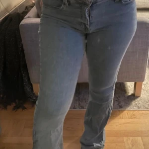 Blå bootcut jeans med låg midja - Snygga blå jeans med bootcut-modell och låg midja. Jeansen har klassiska fickor både fram och bak och är tillverkade i ett mjukt denimtyg som sitter skönt. Perfekta för dig som gillar en tidlös och avslappnad stil.