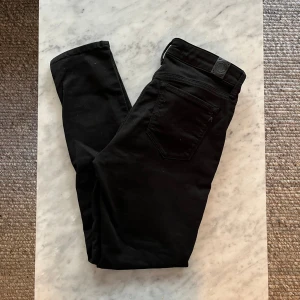 Svarta Replay jeans, midja 28/28 - Svarta jeans från Replay med klassisk femficksdesign och snygga detaljer vid fickorna. Jeansen har normal passform och är tillverkade i ett mjukt bomullsmaterial med lite stretch. Perfekta för dig som gillar stilrena och bekväma byxor.