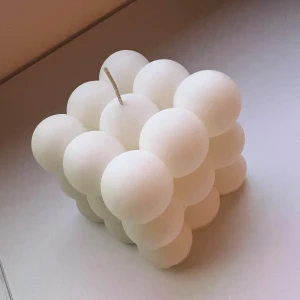 Bubble Cube Candle - Modern dekorativ kub-ljus från inicio, formad av vita sfärer. Mått: 80x80x75 mm. Oanvänt och i mycket gott skick, perfekt som inredningsdetalj eller present. Ger ett stilrent och trendigt intryck i hemmet.