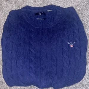 Marinblå kabelstickad tröja från GANT - Kabelstickad marinblå tröja från GANT i premium bomull med storlek S herr. Köpte den ny för 1399 . Mitt pris 229kr. Modellen är 177 och väger 65kg och passar perfekt på.