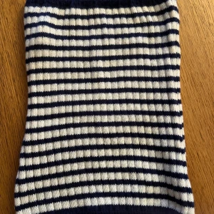 Randig kjol från SHEIN XS - Säljer en stickad kjol från SHEIN i storlek XS. Kjolen är randig i marinblått och vitt, har en rak och enkel form och är gjord i mjuk polyester. Perfekt för dig som gillar en klassisk och stilren look.