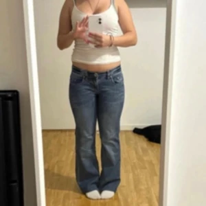 Blå bootcut jeans lågmidjade - Säljer ett par klassiska blå jeans med bootcut passform. Jeansen har låg midja och sitter jättefint
