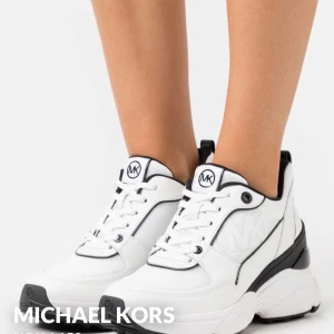 Vita chunky sneakers Michael Kors - Snygga vita chunky sneakers från Michael Kors med svarta detaljer och tydlig MK-logga på sidan och plös. Skorna har snörning och en rejäl platt sula för extra komfort. Perfekta för dig som gillar en sportig och trendig look. Nypris 1945