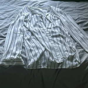 Vit randig skjorta  - Säljer en snygg vit skjorta från Vila med svarta ränder. Skjortan har långa ärmar, klassisk krage och knappar. Den har en brun prick som inte går bort men den syns knappt💕Storlek M