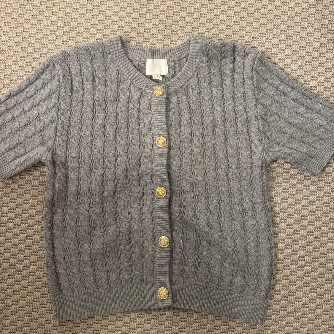 Grå kabelstickad kofta med guldknappar
