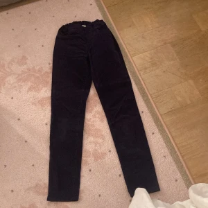 Mörkblå manchesterbyxor strl 140 💙💙💙 - Snygga mörkblå manchesterbyxor från Kappahl i storlek 140. Byxorna har skinny passform, justerbar resår i midjan och klassiska fickor både fram och bak. Perfekta för dig som gillar en stilren look med lite retrovibe! ✨✨✨
