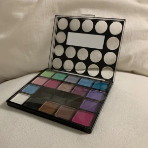 Technic ögonskuggspalett 3st - Färgglad ögonskuggspalett från Technic med 17 olika nyanser, inklusive grönt, blått, lila, rosa, brunt, vitt och svart. Kommer i en smidig plastförpackning med genomskinligt lock och inbyggd spegel. Perfekt för att skapa kreativa och unika ögonlooks. Säljer 3 st för 200 kr.