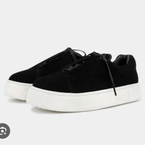 Svarta sneakers med vit plattformssula -  Svarta eytys med tjock vit plattformssula och snörning. Dessa använder jag ej längre, de är väl använda därav priset!