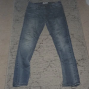 Blå jeans från DENIM, 29/30 - Snygga blå jeans från SNOG/DENIM i klassisk tvätt med lätt slitning. Modellen har raka ben och normal passform, perfekt för en avslappnad stil. Tillverkade i bomull med klassiska fickor både fram och bak.