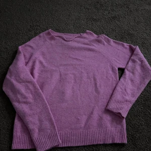 Lila stickad tröja från Vero Moda - Superfin lila stickad tröja från Vero Moda med rund halsringning och ribbade muddar vid ärmslut och nederkant. Perfekt för lager-på-lager och enkel att matcha med jeans eller kjol.
