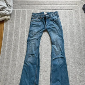 Low waist m. Hål i knäna - Ett par blåa low waist jeans från lager 157 som jag själv sytt ännu mer low samt sprättat upp så att dom ska bli längre och gjort hål i knäna, sydde in dom förmycket så dom blev tyvärr för liten för mig därför jag säljer dom. Står st S men på grund av att jag sytt in dom har dom blivit mindre så skulle säga xs-xxs
