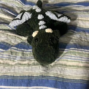 Mörkgrön och ljusblå drake  - Efter önskemål om en drake i likadan färg som tidigare så har jag nu återskapat den mörkgröna draken med ljusblå detaljer. Superhärlig färgkombo så förstår varför den varit uppskattad🤩🩷 OBS:  !Dessa innehåller säkerhetsögon som inte rekommenderas för barn under 3 år!