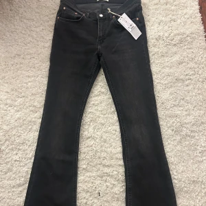 Svarta bootcut jeans från Perfect Jeans - Snygga svarta bootcut jeans från Perfect Jeans i modell med låg midja. Jeansen har klassisk femficksdesign, silverfärgad knapp och nitar samt en lätt tvättad look. Perfekta för dig som gillar en retro vibe och vill ha en bekväm passform.