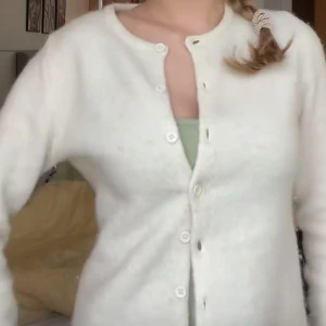 Vit kofta från Gina Tricot, M - Supermysig vit kofta från Gina Tricot i storlek M. Koftan är stickad med rund halsringning och har knappar hela vägen framtill. Perfekt att slänga över en topp när det är kyligt ute. Den är i väldigt bra skick.