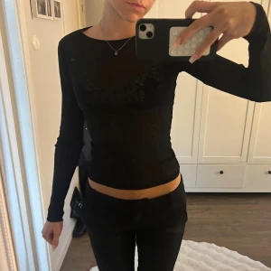 Svart långärmad mesh topp - Säljer en svart långärmad mesh topp med tight passform. Toppen är genomskinlig och har en enkel, stilren design med rund hals. Perfekt att styla med coola smycken eller under en jacka. Snyggt och trendigt plagg för dig som gillar minimalistisk look.