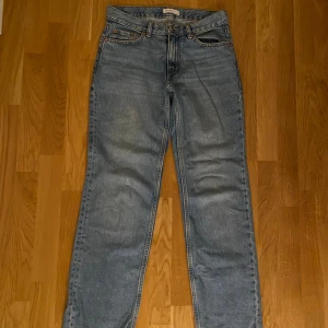 Blå Perfect Jeans straight fit  - Säljer ett par klassiska blå jeans från Gina tricots Perfect Jeans i storlek 34. Jeansen har rak passform och normal midja. De är tillverkade i slitstarkt denimtyg och har en tidlös look med ljus tvätt och subtila slitningar.