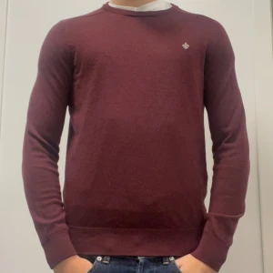 MORRIS MERINOULL TRÖJA - Säljer en vinröd stickad tröja från Morris i 100% merinoull då den blivit för liten. Tröjan har några små tecken på användning och ett hål i mudden som syns på bild 3