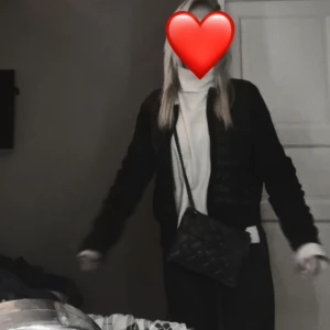 Svart quiltad axelväska Kurt Geiger - Säljer en svart quiltad axelväska från Kurt Geiger med kedjerem och snyggt mönstrad framsida. Väskan har lock med dekorativt spänne och är tillverkad i skinn. Perfekt storlek för det viktigaste och ger en cool vibe till din outfit.